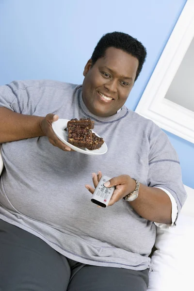 Homem Obeso Assistindo Televisão Enquanto Segurando Prato Pastelaria — Fotografia de Stock