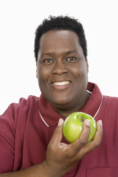 肥胖的非洲裔美国人的画像 他拿着绿色的苹果 背景是白色的 — 图库照片