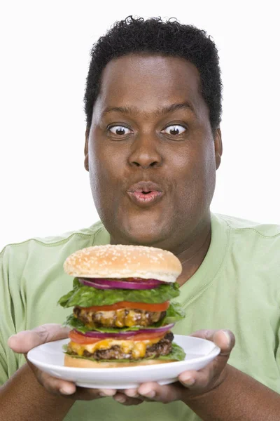 白い背景の上に隔離されたハンバーガーを見て肥満の男 — ストック写真