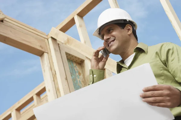 Vista Ángulo Bajo Trabajador Construcción Sonriente Con Teléfono Celular Planos — Foto de Stock