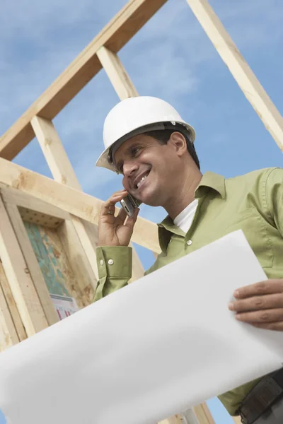 Låg Vinkel Leende Byggarbetare Med Mobiltelefon Och Ritningar Plats — Stockfoto