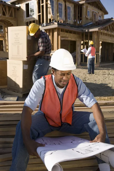 Arkitekt Med Ritning Och Arbetare Som Arbetar Bakgrunden Byggarbetsplatsen — Stockfoto