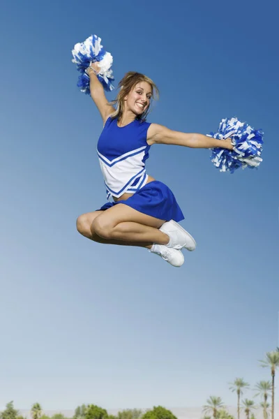 Full Length Young Cheerleader Jumping Pom Poms Sky — Stock Photo, Image