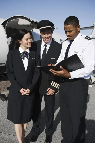 Miembros Tripulación Cabina Multiétnica Discutiendo Informes Con Avión Campo Aviación — Foto de Stock