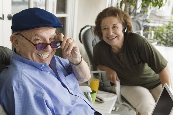 Χαρούμενος Ηλικιωμένος Άνδρας Κρατώντας Γυαλιά Ηλίου Γυναίκα Στο Παρασκήνιο — Φωτογραφία Αρχείου
