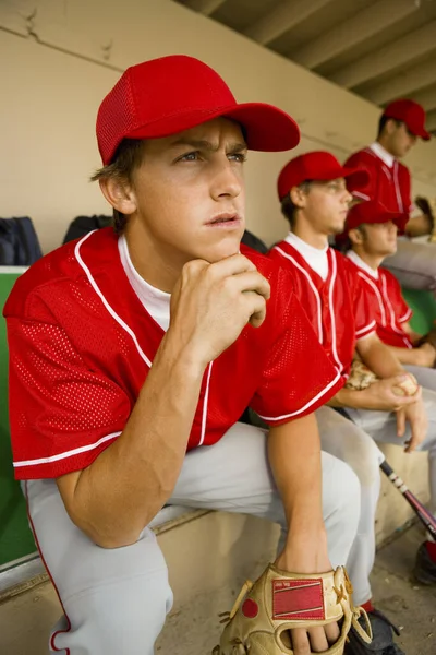 Baseball Spelare Tittar Matchen Intensivt Medan Sitter Dugout Med Andra — Stockfoto