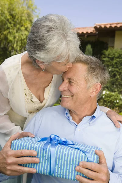 Seniorin Gibt Mann Einen Kuss Und Ein Geburtstagsgeschenk — Stockfoto