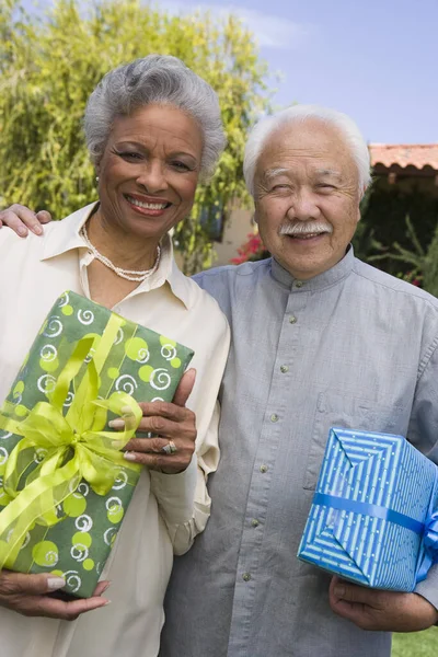 Porträtt Glada Multietniskt Par Står Tillsammans Samtidigt Hålla Presentförpackningar Gräsmattan — Stockfoto
