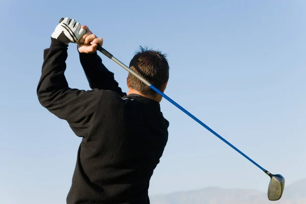 一个年轻人挥动高尔夫球杆的后视镜 — 图库照片