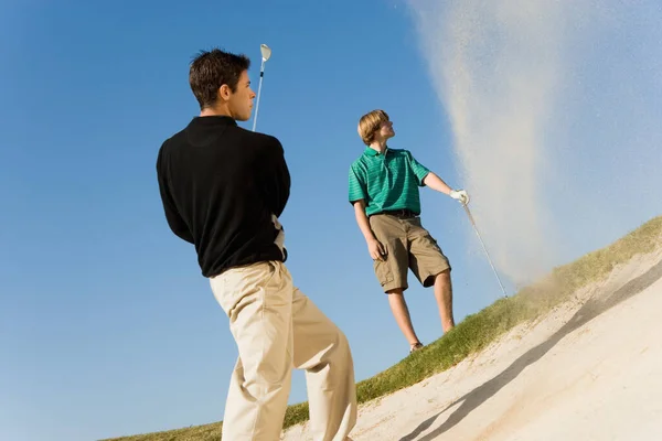 Fiatal Férfi Üti Golf Labdát Homokcsapdából Versenyző Háttérben — Stock Fotó