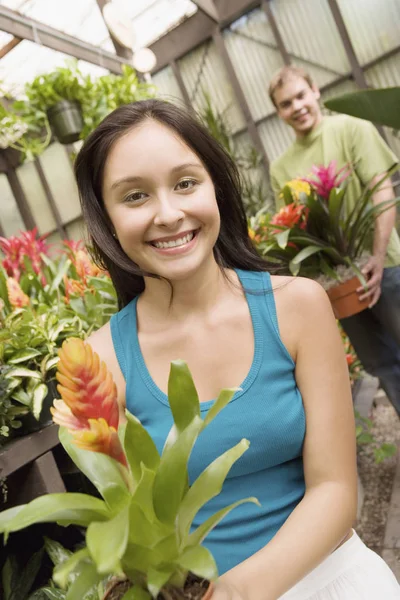 Joyeux Jeune Femme Tenant Plante Pot Avec Homme Arrière Plan — Photo