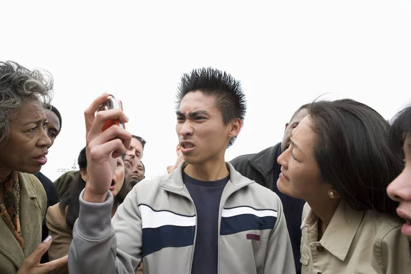 Hombre Joven Mirando Teléfono Con Ira Con Gente Fondo — Foto de Stock