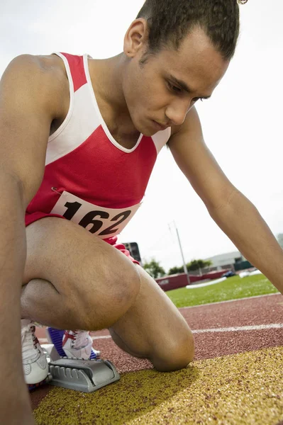 Junger Männlicher Athlet Startblock Auf Der Rennbahn — Stockfoto