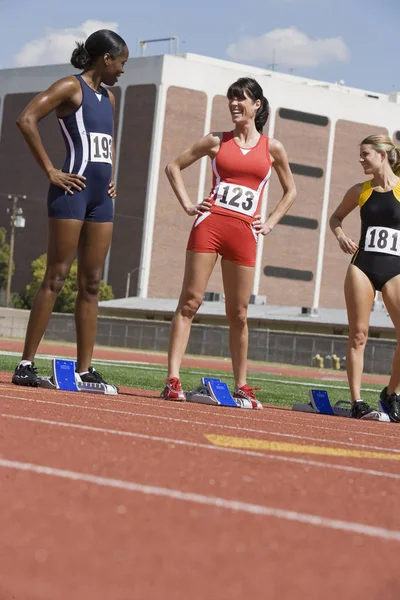 Yarış Pistinde Çok Irklı Bayan Sporcular Başlangıç Bloklarında — Stok fotoğraf
