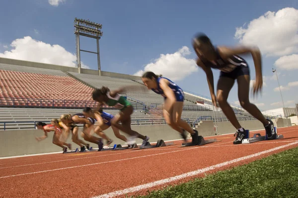 Blurred Motion Diverse Female Athletes Taking Starting Blocks — Stockfoto