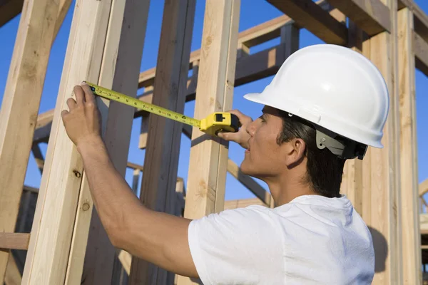 Medelålders Byggnadsarbetare Som Mäter Träbjälkar Plats — Stockfoto