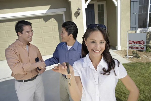 Portrait Young Woman Holding Keys While Man Shaking Hands Agent Royalty Free Stock Photos