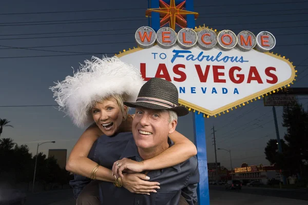 Portrait Happy Mature Man Piggybacking Woman Las Vegas Sign Background — Stock Photo, Image