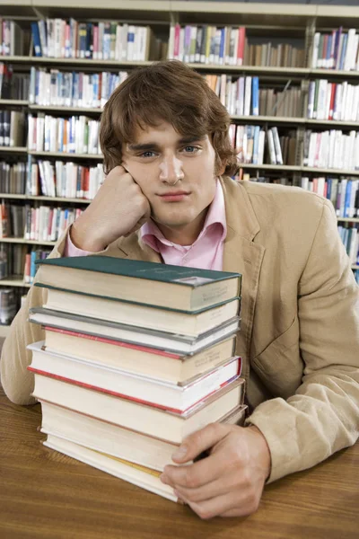 Retrato Estudante Universitário Entediado Mesa Com Pilha Livros Biblioteca — Fotografia de Stock