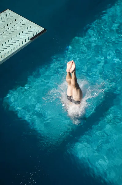 プールに潜る白人女性水泳選手の足の高角度ビュー — ストック写真
