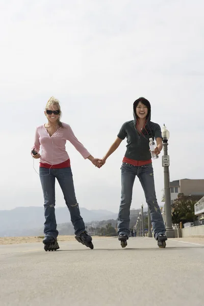 Comprimento Total Mulheres Jovens Patinando Enquanto Segurando Mãos Rua — Fotografia de Stock