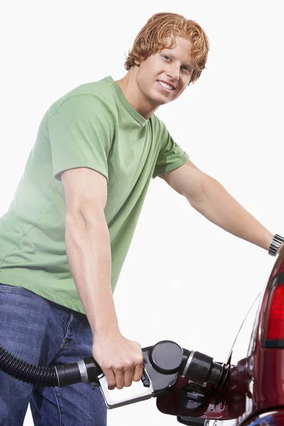 白い背景に隔離された彼の車を給油幸せな男の肖像画 — ストック写真