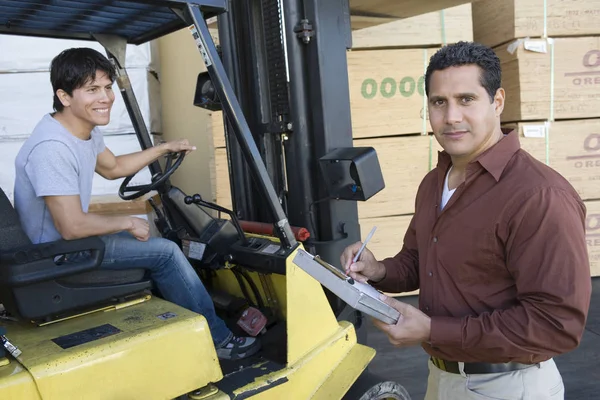 창고에서 트럭을 운전하고 노동자와 클립보드 남자의 — 스톡 사진