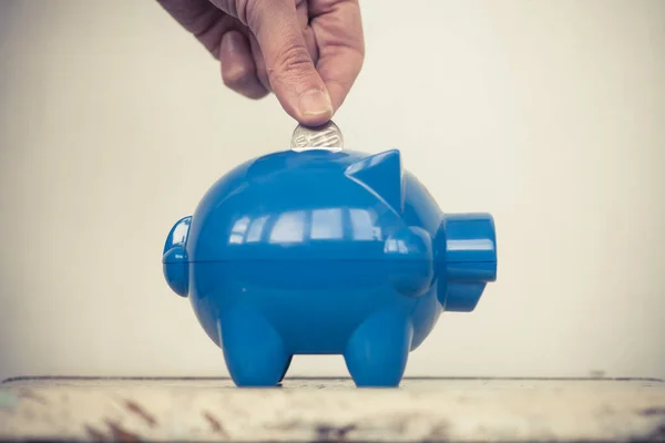 青い貯金とコインを追加する人のイメージ カラー — ストック写真