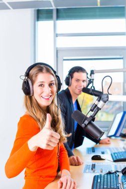 Presenters or moderators - man and woman - in radio station hosting show for radio live in Studio clipart