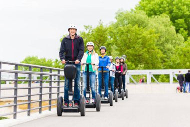 Tourist group having guided Segway city tour in Germany clipart