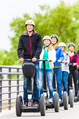 Tourist group having guided Segway city tour in Germany clipart