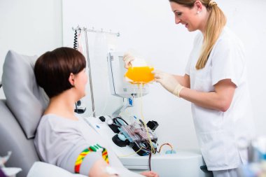 Nurse showing patient donating own blood in hospital her blood plasm clipart