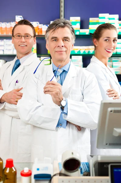 Farmacêutico Com Sua Equipe Farmácia Farmácia Frente Prateleiras Com Produtos — Fotografia de Stock