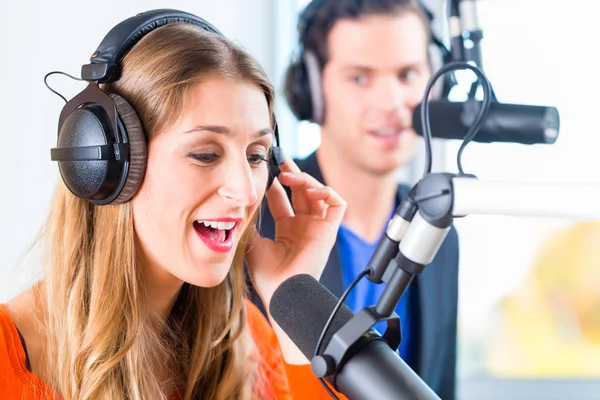 Presenters or moderators - man and woman - in radio station hosting show for radio live in Studio