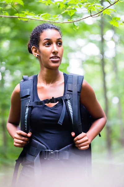 African young woman hiking on forest track