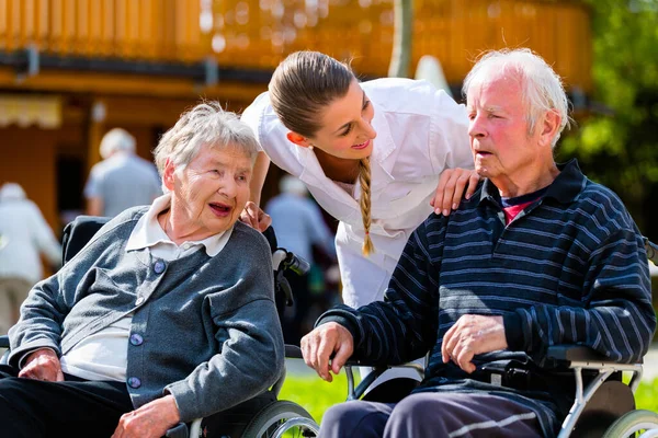 老夫妇 老年男女 和护士一起在养老院的花园里 — 图库照片