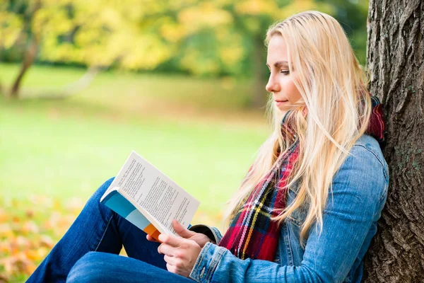Žena Čtení Knihy Podzimním Parku Sedí Louce Pokryté Listím — Stock fotografie