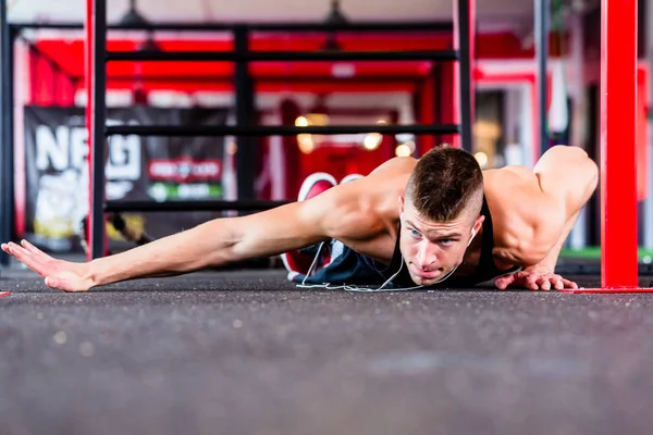 Man exercising doing push-up on floor of sport fitness gym