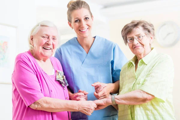 Elderly care nurse with two senior women