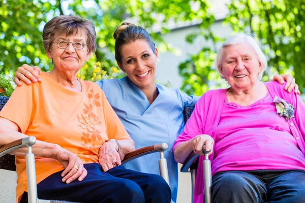 Γηριατρική Νοσοκόμα Συνομιλεί Ηλικιωμένες Γυναίκες — Φωτογραφία Αρχείου