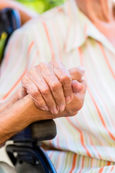 看護師の車椅子に年配の女性の手を握って — ストック写真