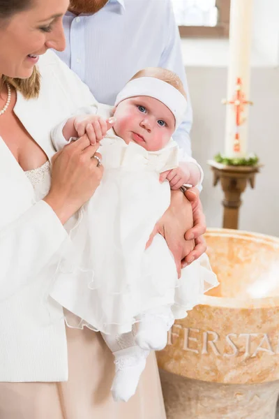 若い親が洗礼を施すガウンを着て 赤ちゃんの教会で — ストック写真