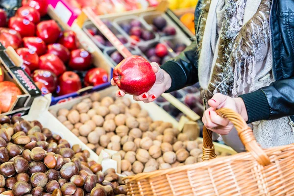 Woman buying fruit on market booth