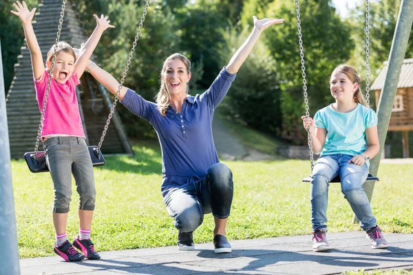 Familie Mit Zwei Mädchen Und Mutter Auf Spielplatzschaukel — Stockfoto