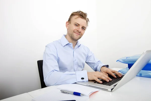 オフィスのデスクでノートパソコンを使用して幸せなビジネスマンの肖像画 — ストック写真