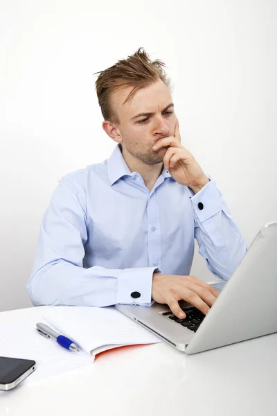 オフィスのデスクでノートパソコンを使用している思慮深いビジネスマン — ストック写真