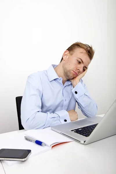 オフィスの机の上にノートパソコンを持つ疲れたビジネスマン — ストック写真