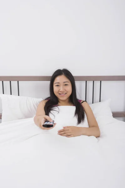 Portrait Smiling Woman Changing Channels Remote Control Bed — Stock Photo, Image