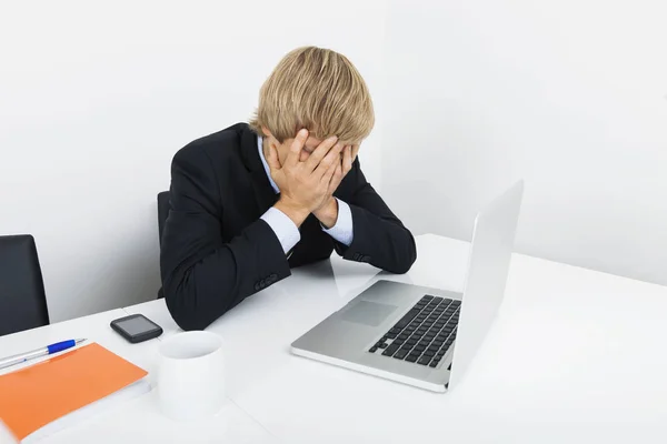 Zmęczony Biznesmen Rękami Twarzy Siedzi Przy Biurku Przy Laptopie — Zdjęcie stockowe
