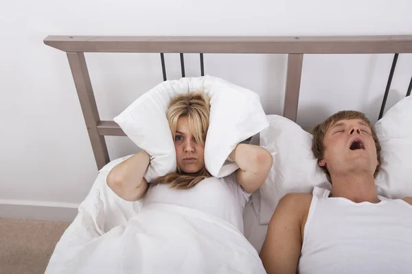 Frustrated Woman Covering Ears Pillow While Man Snoring Bed — Stock Photo, Image